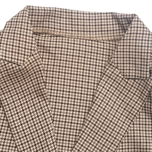 Détail du revers d'un blazer marron à motif pied-de-poule avec texture en laine rétro