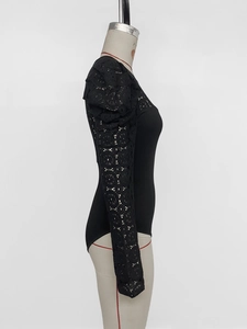 Close-up of black lace puff sleeves and floral mesh texture on a slim bodysuit