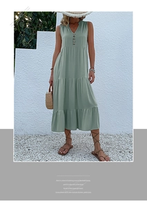 Detail of sage green tiered maxi dress with V-neckline and decorative wooden buttons