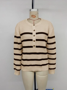 Detailed close-up of chunky knit texture and contrast buttons on a striped cardigan