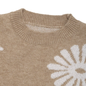 Nahaufnahme von Rundhalsausschnitt und weißen Gänseblümchen auf Kamel-Strickpullover