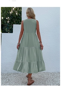 Rear view detail of green sleeveless tiered maxi dress with pleated layers in outdoor setting