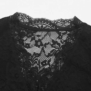 Detailed close-up of intricate black floral lace neckline with scalloped edge on bodysuit