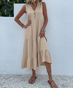 Detail of V-neckline with brown wooden buttons on a beige sleeveless tiered maxi dress