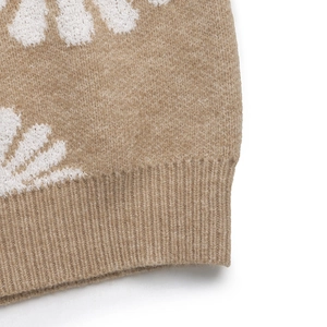 Detailaufnahme des kamelfarbenen Strickpullovers mit weißen Blumen und Rippbündchen