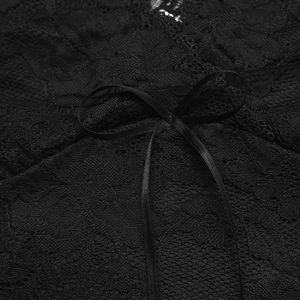 Dettaglio del pizzo floreale nero e del fiocco di raso sulla maglia a maniche lunghe sexy