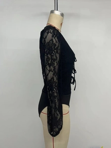 Close-up of black floral lace bodysuit featuring long sheer sleeves and front lace-up detail