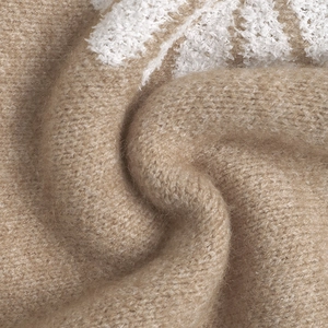 Nahaufnahme von khakifarbenem Strickstoff mit Blumenmuster und weicher Textur