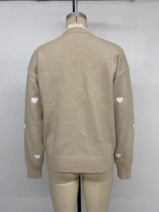Rear view of beige v-neck knit sweater featuring white heart embroidery on long sleeves