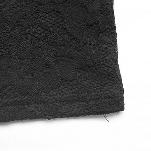 Dettaglio macro del pizzo floreale nero con trama a rete e cuciture sul bordo del capo