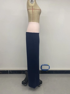 Detail view of wide contrast pink elastic waistband on dark blue casual wide leg trousers