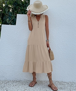 Detail of V-neck tiered sleeveless midi dress with buttons and summer beach accessories