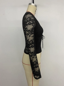 Dettaglio della manica in pizzo nero con fiocco laterale su un top alla moda