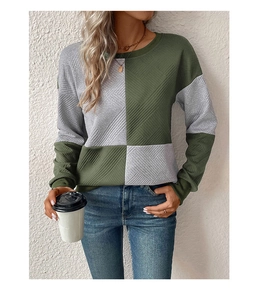 Detail of grey and olive green patchwork sweatshirt showing textured diamond twill fabric