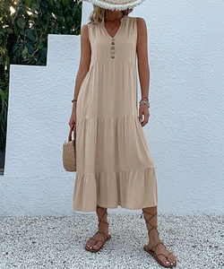Detail of bohemian tiered maxi dress featuring V-neckline with decorative buttons
