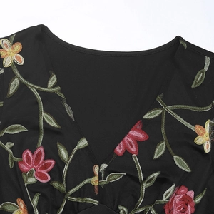 Gros plan du col en V avec broderie florale colorée sur un body noir pour femme