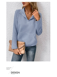 Detailansicht hellblaues Struktur-Sweatshirt mit Reverskragen und Metallknopf-Akzenten
