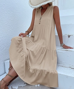 Detail view of V-neck beige summer dress with tiered skirt and decorative button closure