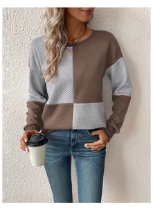 Detail shot of brown and grey colorblock knit sweater showing twill texture and crew neck
