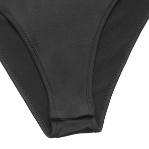 Détail de la fermeture à boutons-pression et du tissu en maille noire sur un body