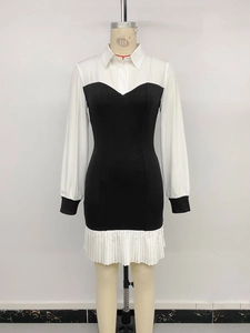 Detail of black and white contrast dress showing shirt collar and pleated hemline finish