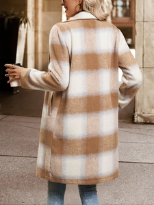 Gros plan sur la texture du manteau en laine avec motifs à carreaux beige et bleu