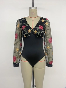 Détail de broderie florale sur manches longues en mesh d'un body noir à col en V