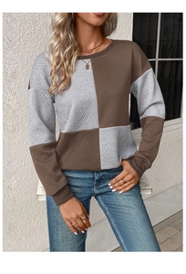 Detail of grey and brown patchwork sweatshirt with textured diamond quilted fabric