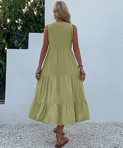 Rear view of women's olive green sleeveless tiered midi dress in a summer garden setting