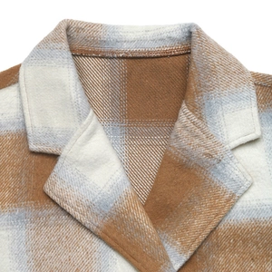 Gros plan du revers d'un manteau en laine à carreaux marron avec texture brossée