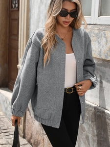 Detail of grey loose jacket featuring diagonal twill texture and metal snap buttons