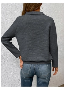 Detailansicht der Rückseite eines dunkelgrauen Sweatshirts mit gesteppter geometrischer Textur