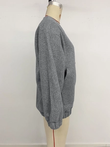 Detail of gray long-sleeve jacket showing textured fleece fabric and side pockets