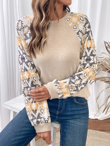 Close-up of beige waffle knit top with ethnic geometric print sleeves and ribbed cuffs