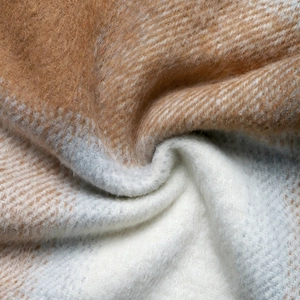 Gros plan sur la texture du tissu en laine à carreaux marron et blanc doux