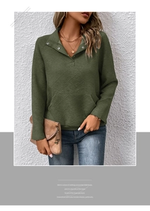 Details eines dunkelgrünen Sweatshirts mit geometrischer Diagonalstruktur und Druckknöpfen