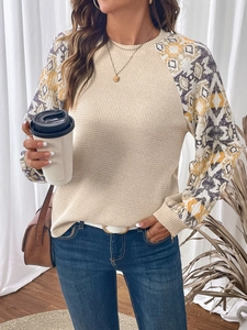 Detail of waffle knit fabric and geometric ethnic print sleeves on long sleeve top