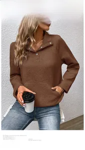Detail der Rautensteppung und des silbernen Druckknopfkragens an einem braunen Sweatshirt