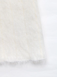 Detail of soft white plush knit fabric with fluffy texture on flared sleeve sweater