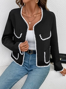 Gros plan sur une veste noire en tweed avec bordures en dentelle blanche et tissu gaufré