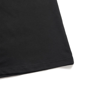 Gros plan détaillé montrant les coutures doubles de qualité sur l'ourlet noir du pantalon