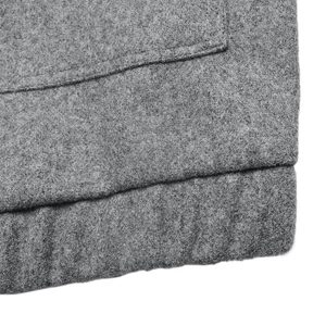 Detail einer grauen Wolljacke mit hochwertigen Nähten und weicher Stofftextur