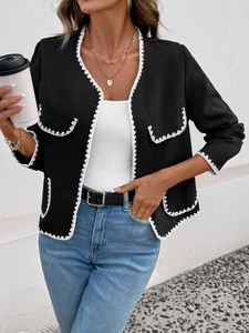 Gros plan sur la veste noire à texture gaufrée avec dentelle festonnée blanche