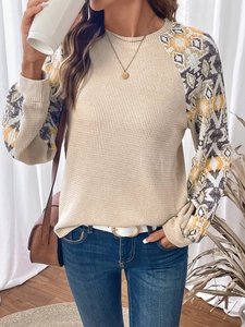 Close-up of beige waffle knit texture and geometric ethnic print on long sleeves