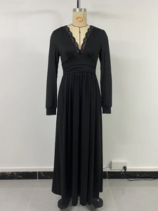Détail de l'élégant col en V avec bordure en dentelle sur une robe noire longue ajustée