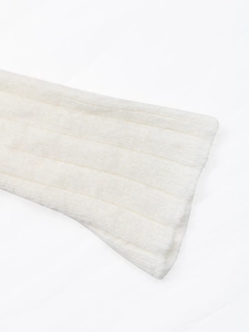 Close-up of white ribbed knit fabric showing soft mink texture and delicate flare sleeve detail