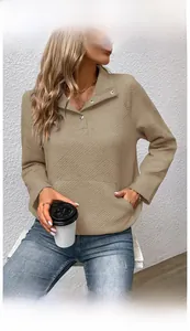 Detail eines khakifarbenen Stepp-Pullovers mit Rautenmuster und Polokragen