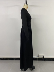 Détail de la taille plissée et de la coupe ajustée de cette robe longue noire à col en V