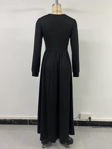 Détail macro des plis à la taille sur une élégante robe longue noire à manches longues