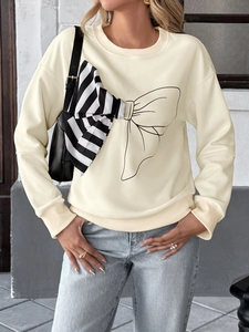 Detail of sweatshirt with 3D black and white striped bow and artistic graphic design